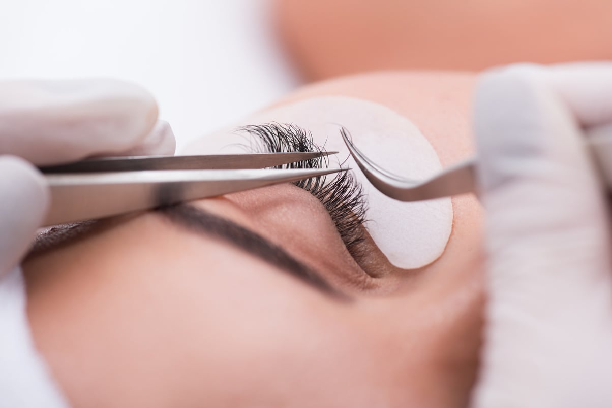 Beautiful young woman during eyelash extension